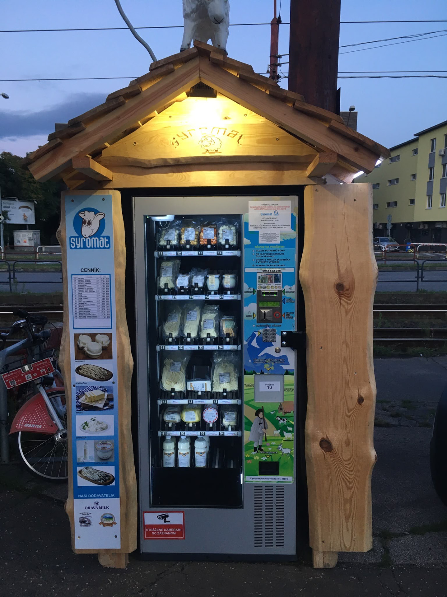 Mliečny automat Syromat v drevenom stánku pod šopou s motívom ovce